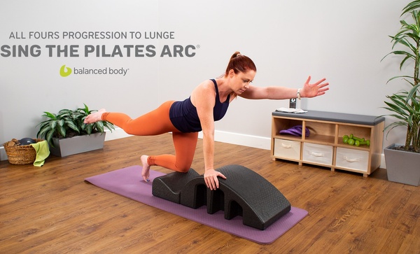 All fours progression to lunge using the pilates arc Woman exercising on mat with pilates arc
