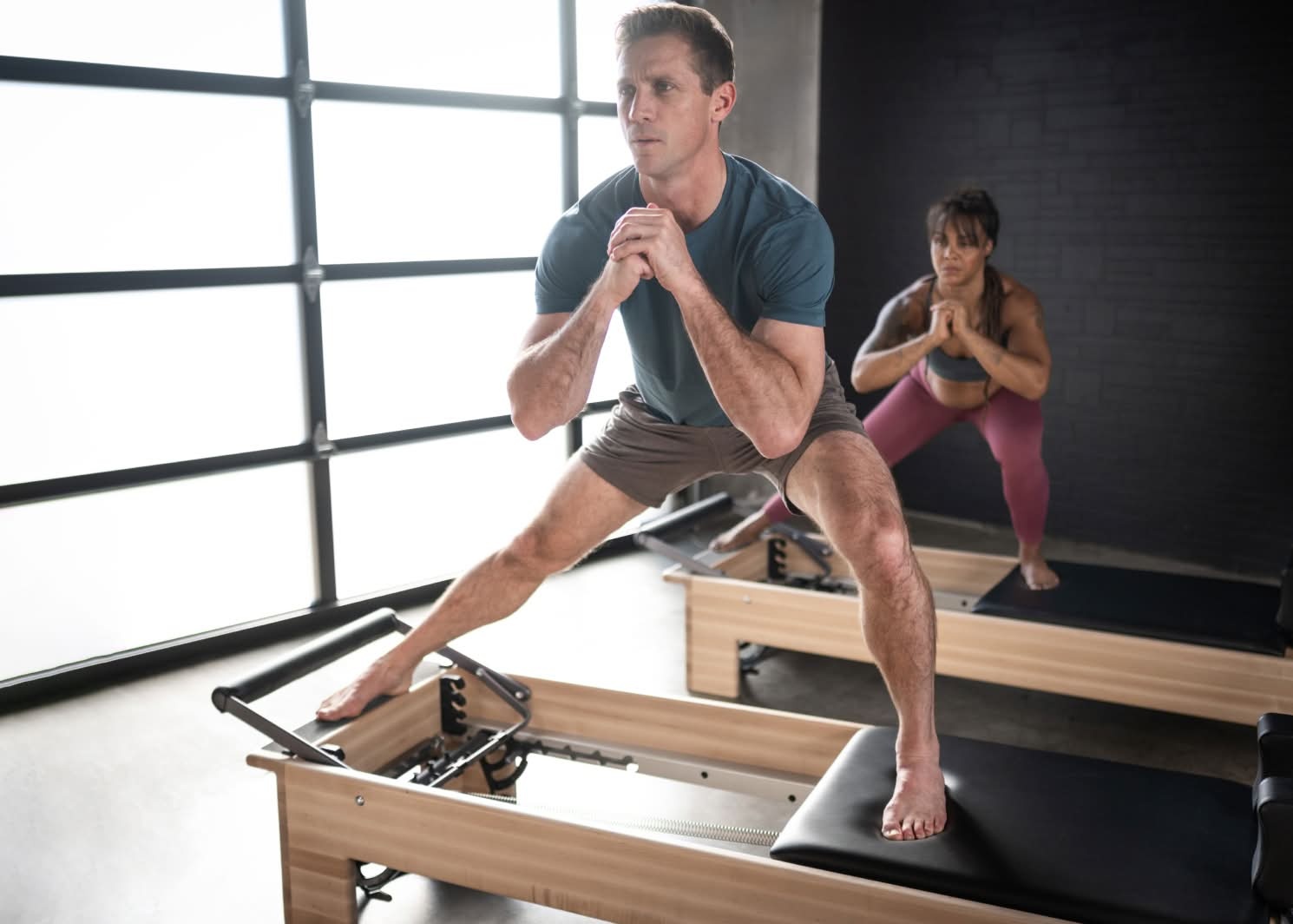 two people standing studio reformer
