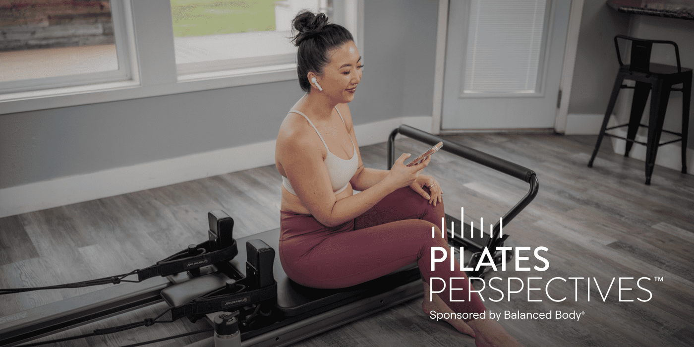 woman listening to podcast while sitting on reformer